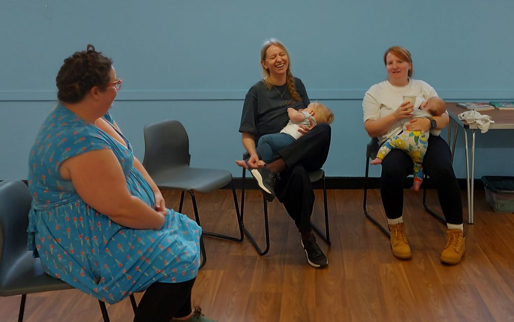 Mums chatting and feeding babies at Sling Library Meet Up in Eastney Portsmouth.